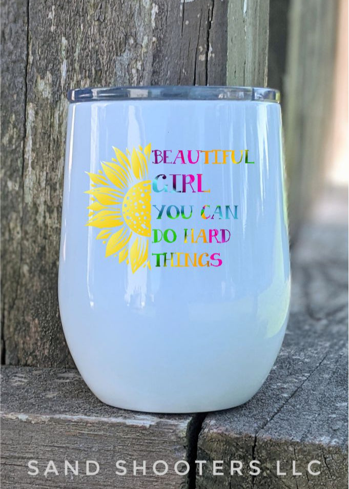 Photo of a white 12 oz wine tumbler with color printed image of a sunflower and text that reads "Beautiful girl, you can do hard things."